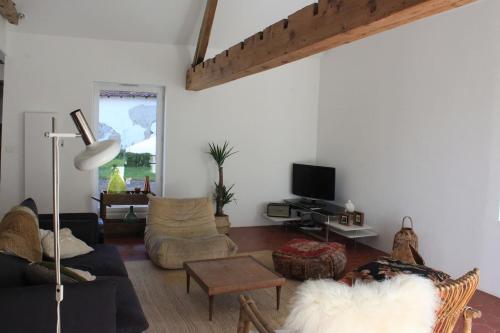 sala de estar con sofá y TV en Les Bleuets, en Rue