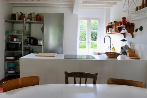 a kitchen with a counter and a table and chairs at Les Bleuets in Rue