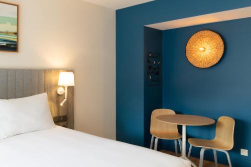 a hotel room with a bed and a table and chairs at Staybridge Suites - Cannes Centre by IHG in Cannes