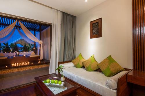 a living room with a couch and a large window at THE PRIVILEGE FLOOR by Borei Angkor in Siem Reap