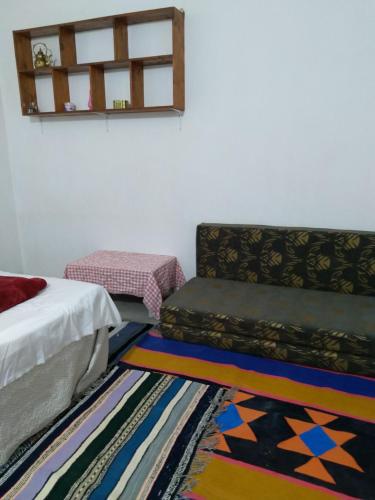 a bedroom with a bed and a couch and a rug at DAR BRAHIM 
