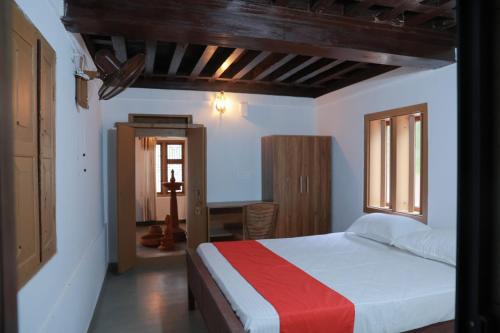 a bedroom with a bed with a red and white blanket at Best Heritage Home in Iritti