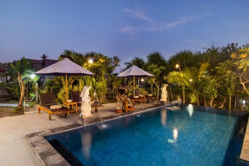 a swimming pool with chairs and umbrellas at a resort at Bagus Dream Beach Villa Lembongan in Nusa Lembongan