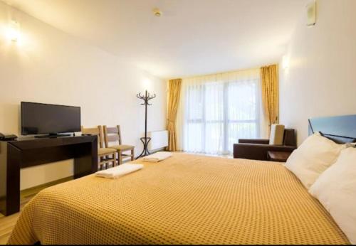 een slaapkamer met een groot bed en een gele deken bij Къща за гости и спорт Анелия in Vŭrben