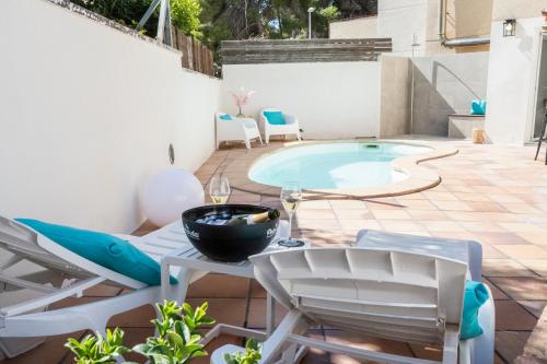 un patio con tavolo, sedie e piscina di VILLA WINE & BEACH Design and Luxury in Cala Crancs a Salou