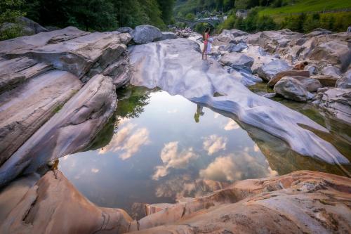 a reflection of the sky in a pool of water at Casa Mima Chalets in Gerra Verzasca