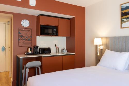 a hotel room with a bed and a kitchen at Staybridge Suites - Cannes Centre by IHG in Cannes