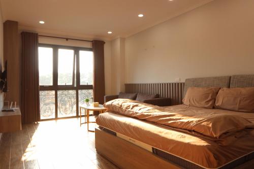 - une chambre avec un lit et une grande fenêtre dans l'établissement Funhome Apartment Giang Vo Ha Noi, à Hanoï
