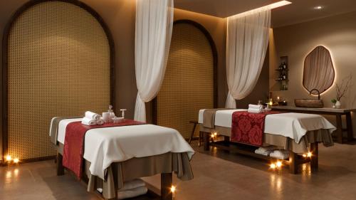 a hotel room with two beds and a mirror at Mandala Cham Bay Mui Ne in Phan Thiet
