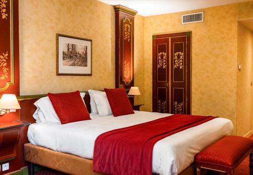 1 dormitorio con 1 cama grande con almohadas rojas en Villa Beaumarchais en París