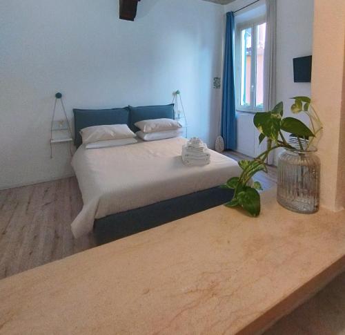 een slaapkamer met een bed en een potplant bij La casa nel borgo in Parma