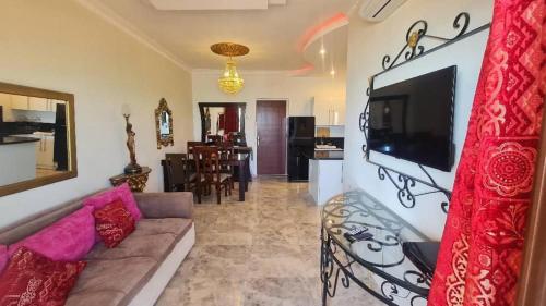a living room with a couch and a tv on a wall at Beach Front View Boutique Apartment in Hurghada