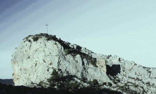 a mountain with a cross on top of it at Rural EL METGE Penáguila con chimenea in Penáguila