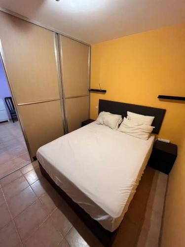 łóżko z białą pościelą i poduszkami w pokoju w obiekcie Mies de Estrada w mieście Comillas