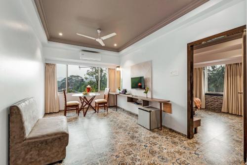 a living room with a table and a dining room at Emerald Retreat in Lonavala