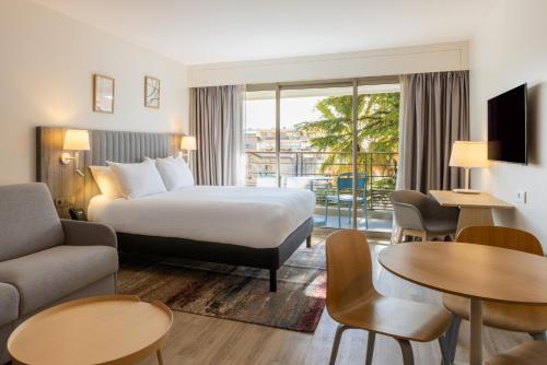 a hotel room with a bed and a balcony at Staybridge Suites - Cannes Centre, an IHG Hotel in Cannes