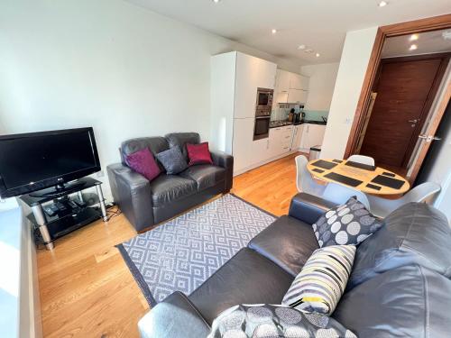 a living room with a leather couch and a flat screen tv at Deluxe Central Entire Flat at Farringdon Station London in London