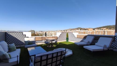 a patio with couches and tables on a roof at Hotel Saray in Granada