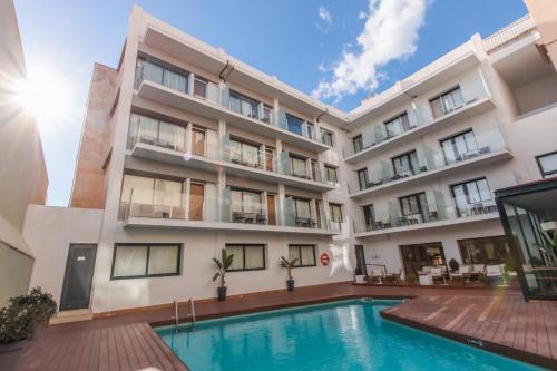 an apartment building with a swimming pool at Hotel Lauria in Tarragona