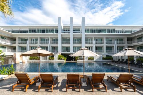 una vista exterior de un hotel con sillas y sombrillas en Kantary Hills Hotel, Chiang Mai, en Chiang Mai