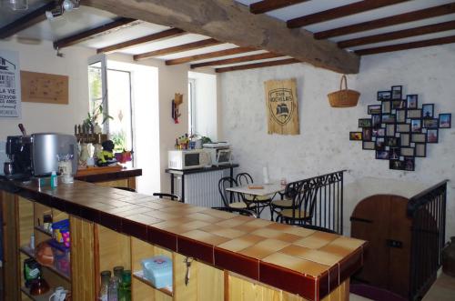 cocina con encimera y mesa en una habitación en Maison d'Hôtes Le Cadran Solaire, en Courcelles