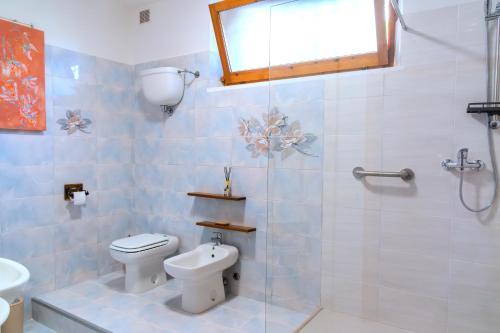 a bathroom with a toilet and a glass shower at Casa Italia - Appartamento con giardino in Sinalunga
