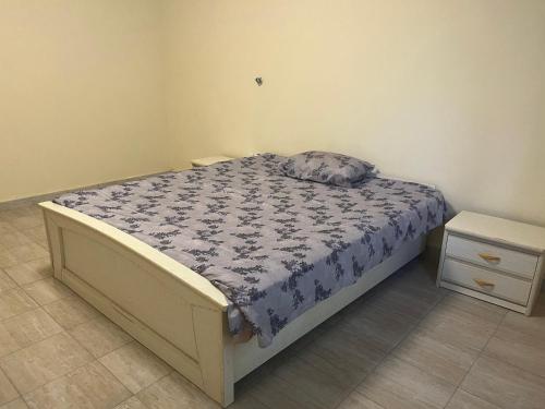 um quarto com uma cama com um edredão azul e branco em Residence ABIS 