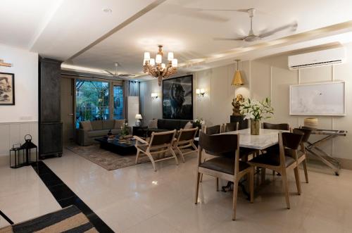 新德里的住宿－R6 Luxury Peacefull & Comfortable，用餐室以及带桌椅的起居室。