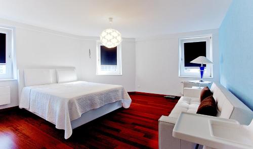 チューリッヒにあるPresidental Suite Apartment by Livingdowntownの白いベッドルーム(ベッド1台、ソファ付)