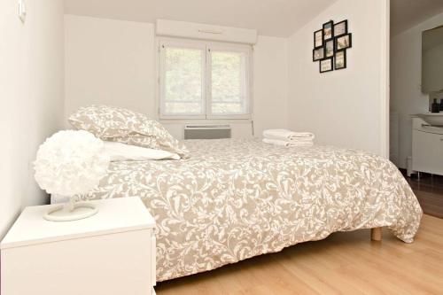 ein weißes Schlafzimmer mit einem Bett und einem Fenster in der Unterkunft Entre Terre et Mer- 4 personnes in Saint-Brieuc