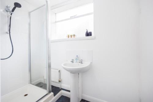 y baño blanco con lavabo y ducha. en Modern Apartment - Perfect Location - by Luxiety stays serviced accommodation Southend on Sea, en Southend-on-Sea