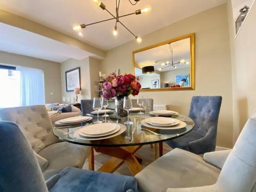 a dining room with a glass table and chairs at Chic Clifton Home – inviting décor & outdoor space in Bristol