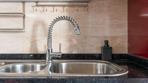 a kitchen sink with a faucet in a kitchen at Charming and Calm House - 5 minutes from the Beach by car in Vila Nova de Gaia