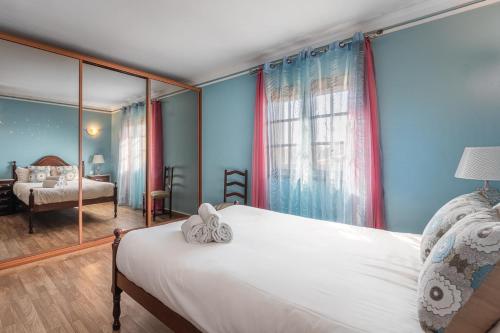 a bedroom with blue walls and a bed with a mirror at Charming and Calm House - 5 minutes from the Beach by car in Vila Nova de Gaia