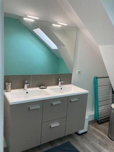 La salle de bains est pourvue d'un lavabo blanc et d'un plafond bleu. dans l'établissement Appartement T3 73 m2 villa Les Tamaris Aix-les-Bains, à Aix-les-Bains