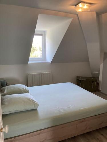 un lit blanc dans une chambre avec une fenêtre dans l'établissement Appartement T3 73 m2 villa Les Tamaris Aix-les-Bains, à Aix-les-Bains