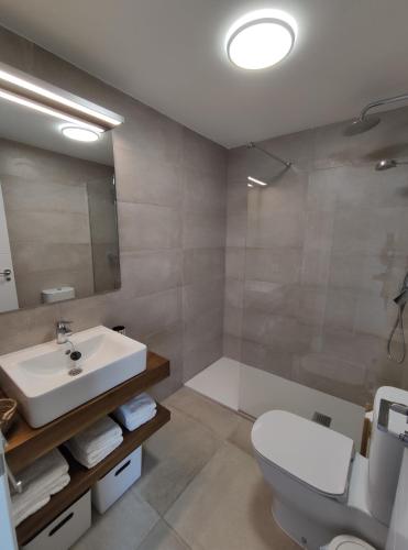 a bathroom with a sink and a toilet and a shower at CASA ROMPEOLAS Atlanterra in Zahara de los Atunes