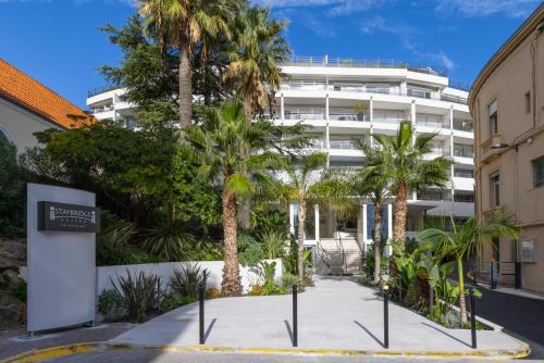 una strada con palme di fronte a un edificio di Staybridge Suites - Cannes Centre, an IHG Hotel a Cannes