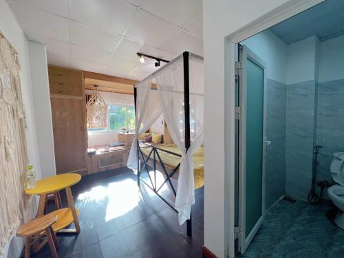 a room with a bed and a bathroom with a shower at Belle House Đà Lạt in Da Lat