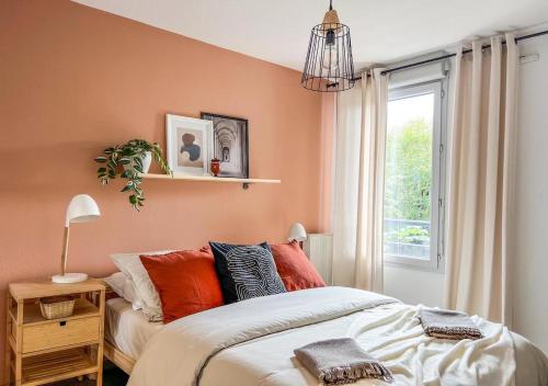 - une chambre avec un lit aux murs orange et une fenêtre dans l'établissement Confortable T2 pour 4 voyageurs, parking privé et terrasse, à Toulouse