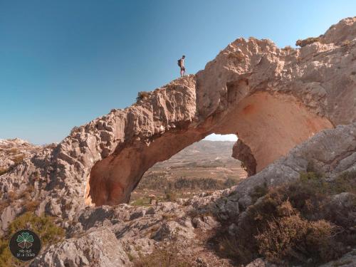 a person standing on top of a rock formation at Rural EL METGE Penáguila con chimenea in Penáguila