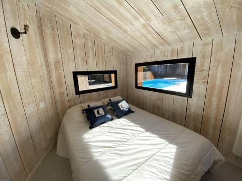 une chambre avec un lit dans un mur en bois dans l'établissement VILLA PALOMA maison moderne piscine chauffée, à La Teste-de-Buch