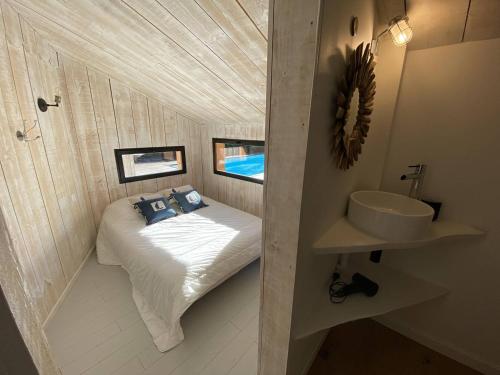 une petite salle de bain avec un lit et un lavabo dans l'établissement VILLA PALOMA maison moderne piscine chauffée, à La Teste-de-Buch