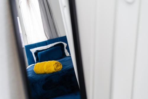 a mirror reflection of a bed with a yellow blanket at 3 bed Gorgeous house AbbeyWood in Abbey Wood