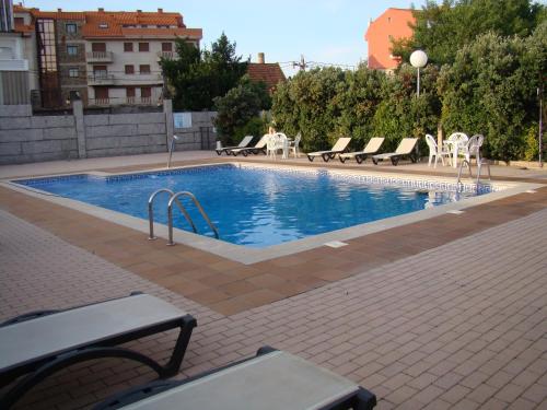 une grande piscine avec des chaises et une table dans l'établissement Hotel Torres Touriño, à Sanxenxo
