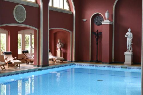 艾爾斯伯里的住宿－哈特韋爾別墅&SPA，一座大型游泳池,位于一座拥有红色墙壁的建筑中