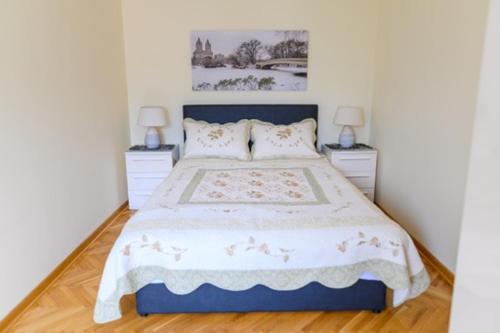 Un dormitorio con una cama grande con dos mesitas de noche. en Apartman Ivanka, en Soko Banja