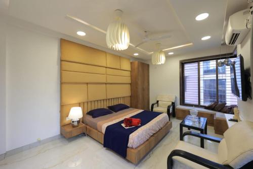 a bedroom with a bed and a couch and a chair at BLUE SKY VILLA in Lonavala