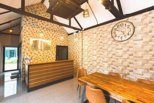 a dining room with a clock on a brick wall at TOBEDzZ HOTEL in Ranong