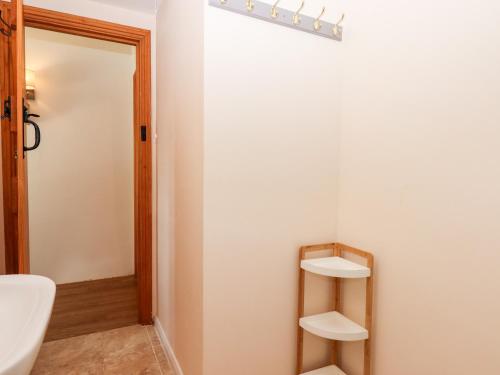 a bathroom with a white wall and a toilet at The Cider House in Saltash